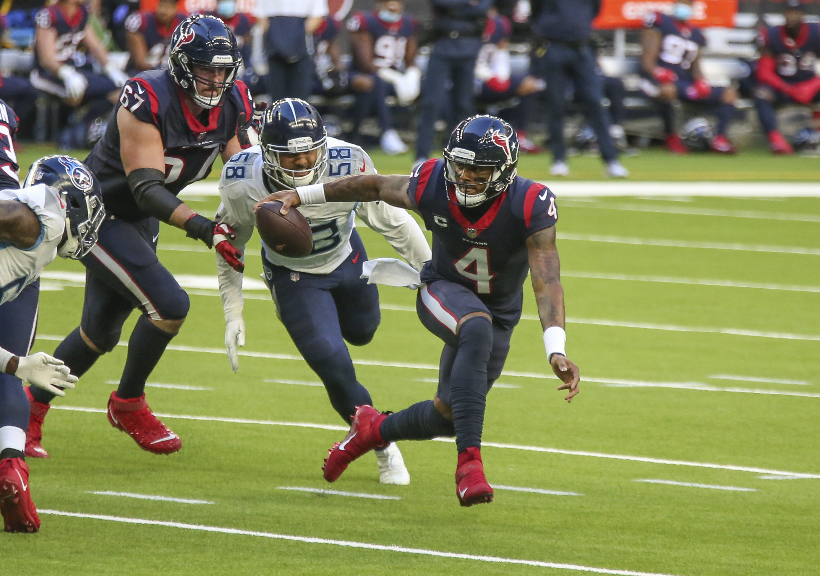 Houston Texans quarterback Deshaun Watson (4) attempts to evade the tackle of Tennessee Titans outside linebacker Harold Landry (58) from a 2020-2021 NFL contest.